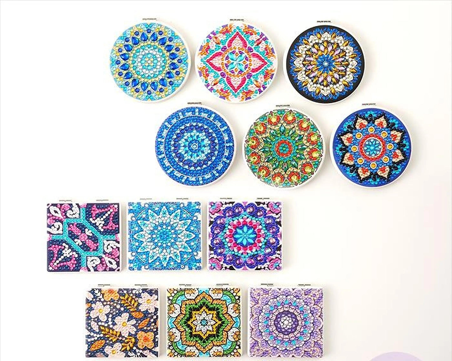 a collection of 12 colorful, intricately designed mirrors or compasses, each with unique patterns and shapes. The mirrors are arranged in a grid-like pattern, showcasing a variety of styles and colors. The text "DIAMONDFIX" is visible, indicating the brand or product name.