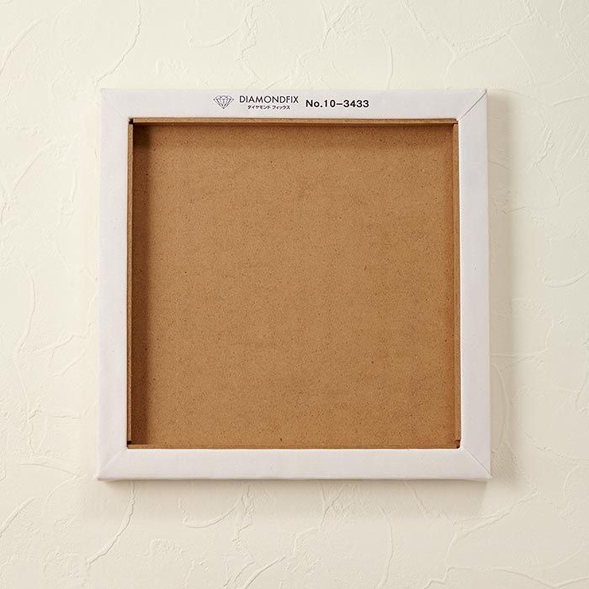A white square frame with a blank canvas inside, mounted on a white wall.