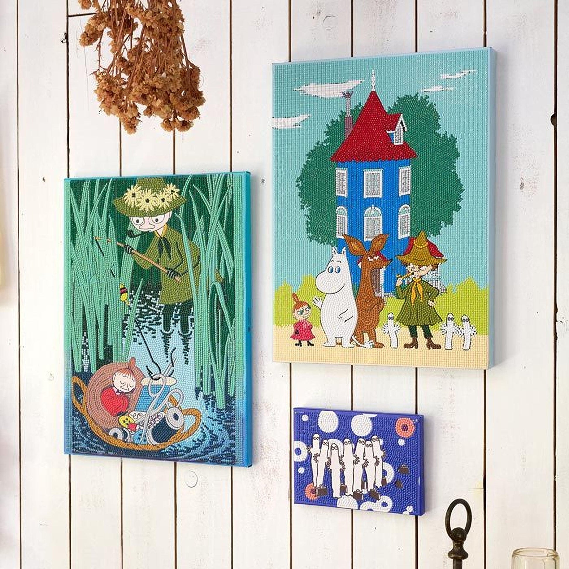 three colorful paintings hanging on a white wall.