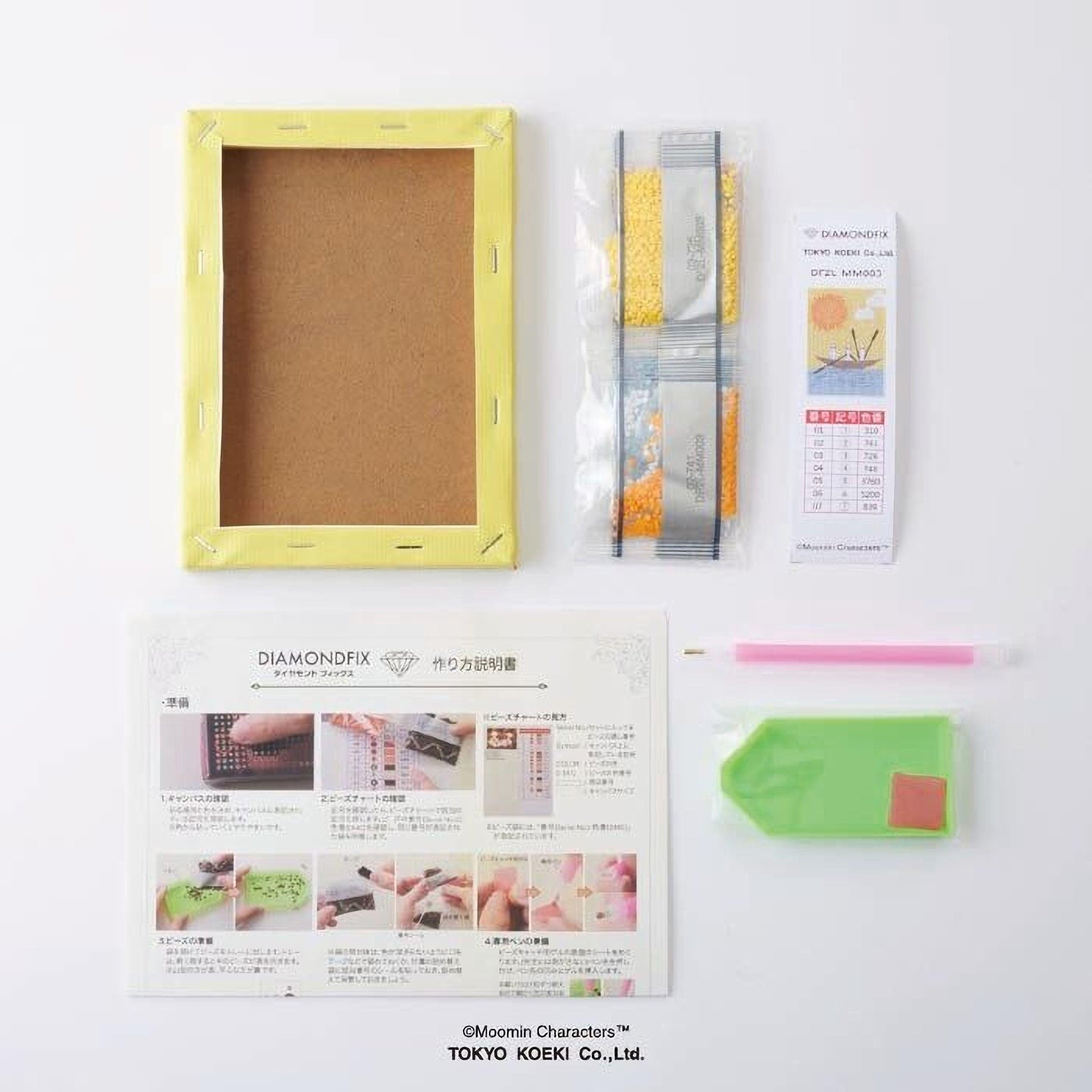 various craft supplies, including a yellow frame, a package of glitter, a pen, and a booklet with instructions.