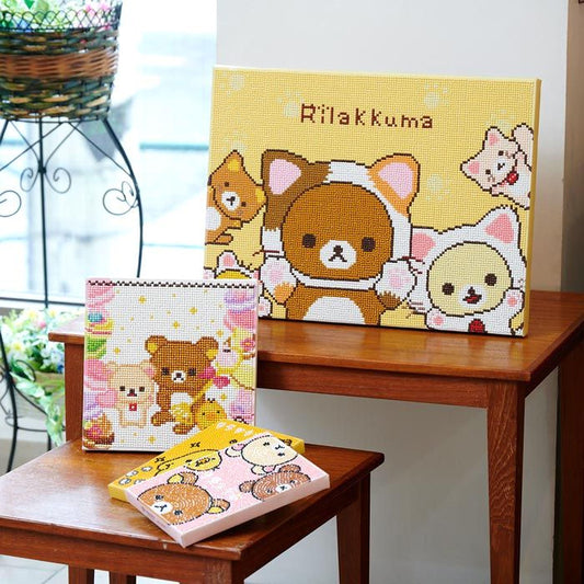 a collection of three different items, including a framed picture of a cartoon character, a small box with a cartoon character, and a small wooden table with a pink box on it.