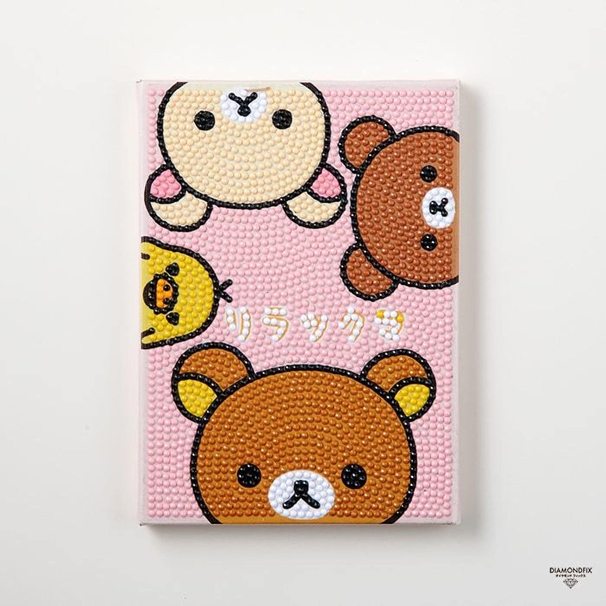 A pink background with three cartoon bear faces and a bird face, along with the text "日本" (Japan) written below the bear faces.