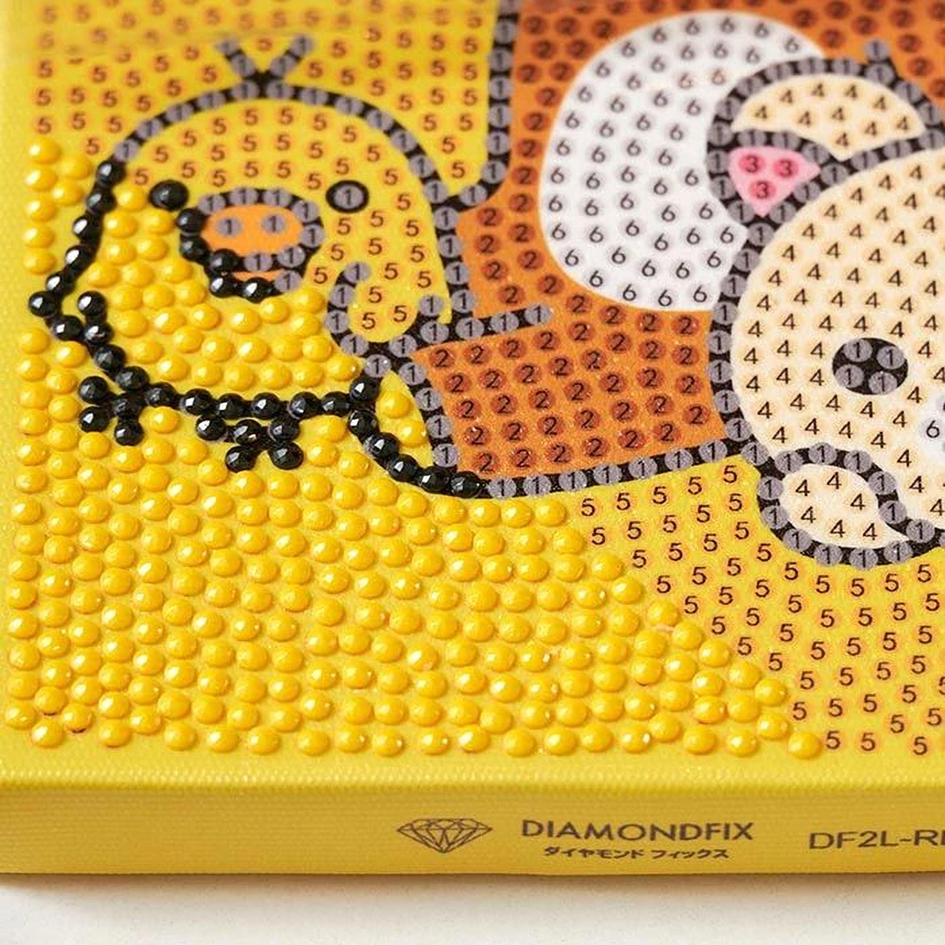 The image is a close-up of a yellow canvas with a pattern of small yellow dots, resembling a diamond-like design.