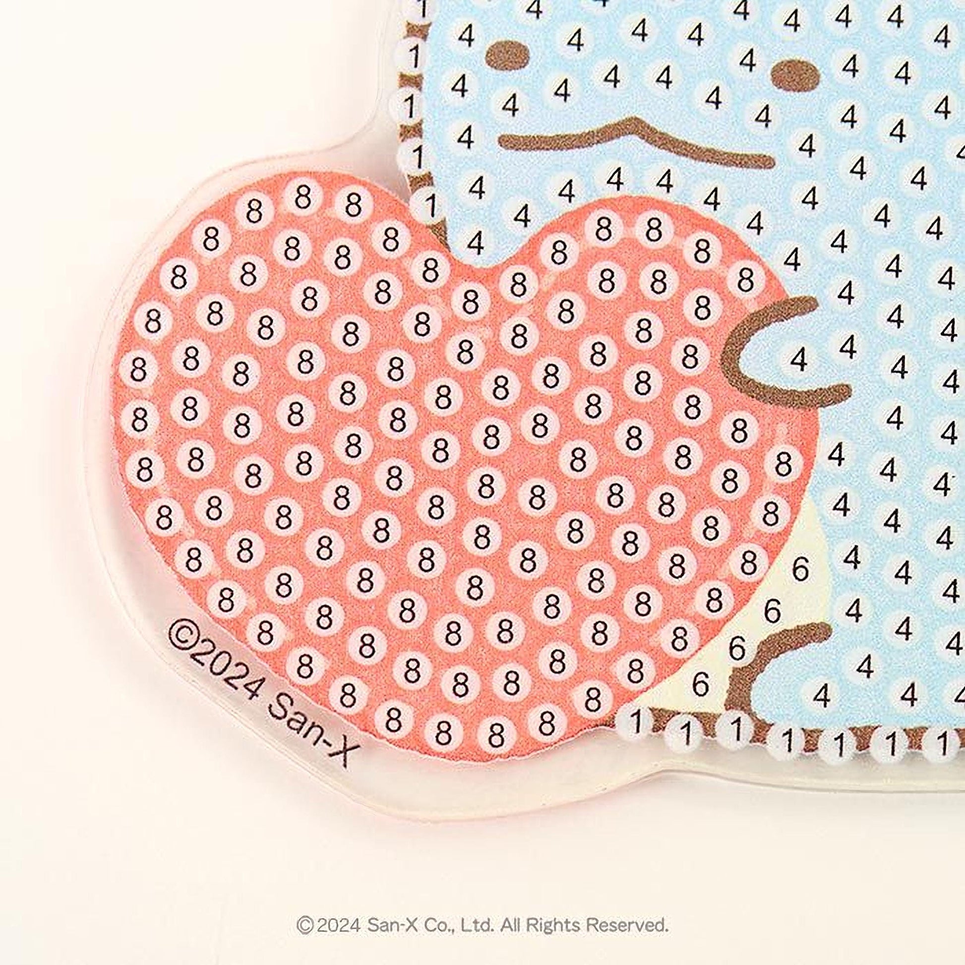 The image is a close-up of a heart-shaped object with a pattern of small circles on it, and there is a blue object with a pattern of small circles on it.