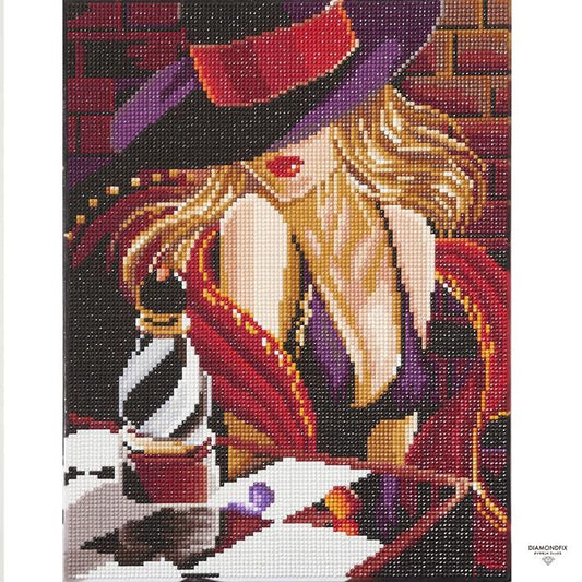 The image is a detailed embroidered or needlepoint design featuring a woman wearing a purple hat and a red scarf, with a bottle of perfume on a table in the background.