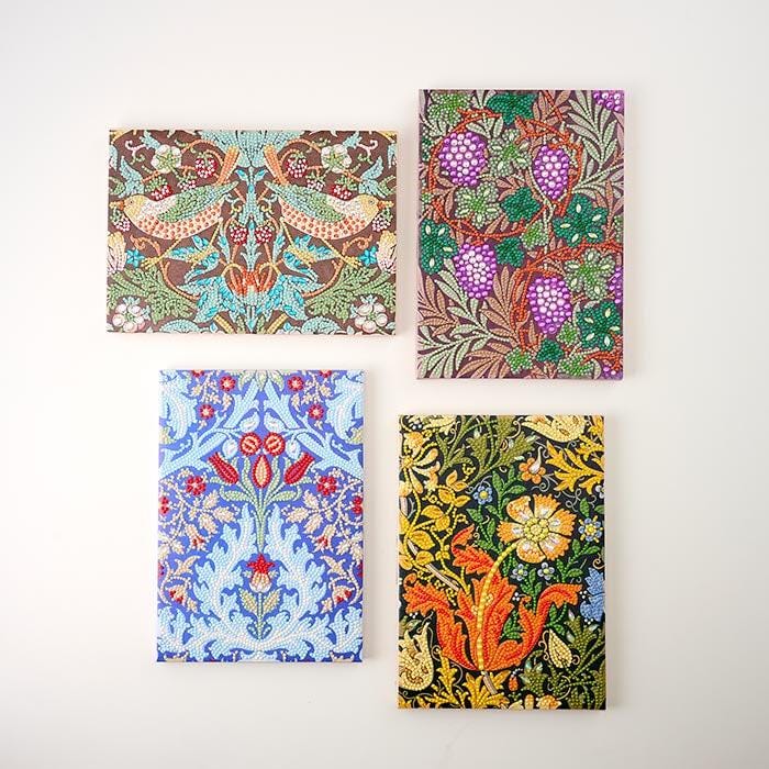 four distinct paintings or prints arranged in a square formation on a white wall.