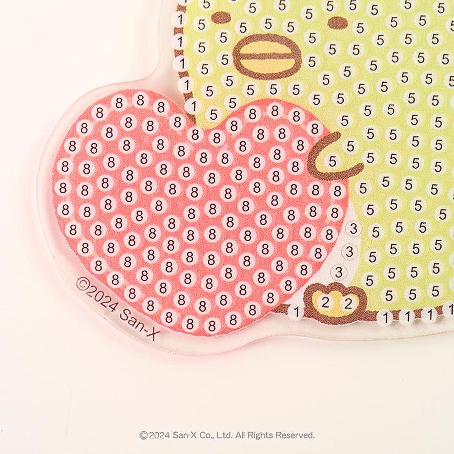 The image is a close-up of a colorful, patterned object with a heart shape and a number grid pattern.