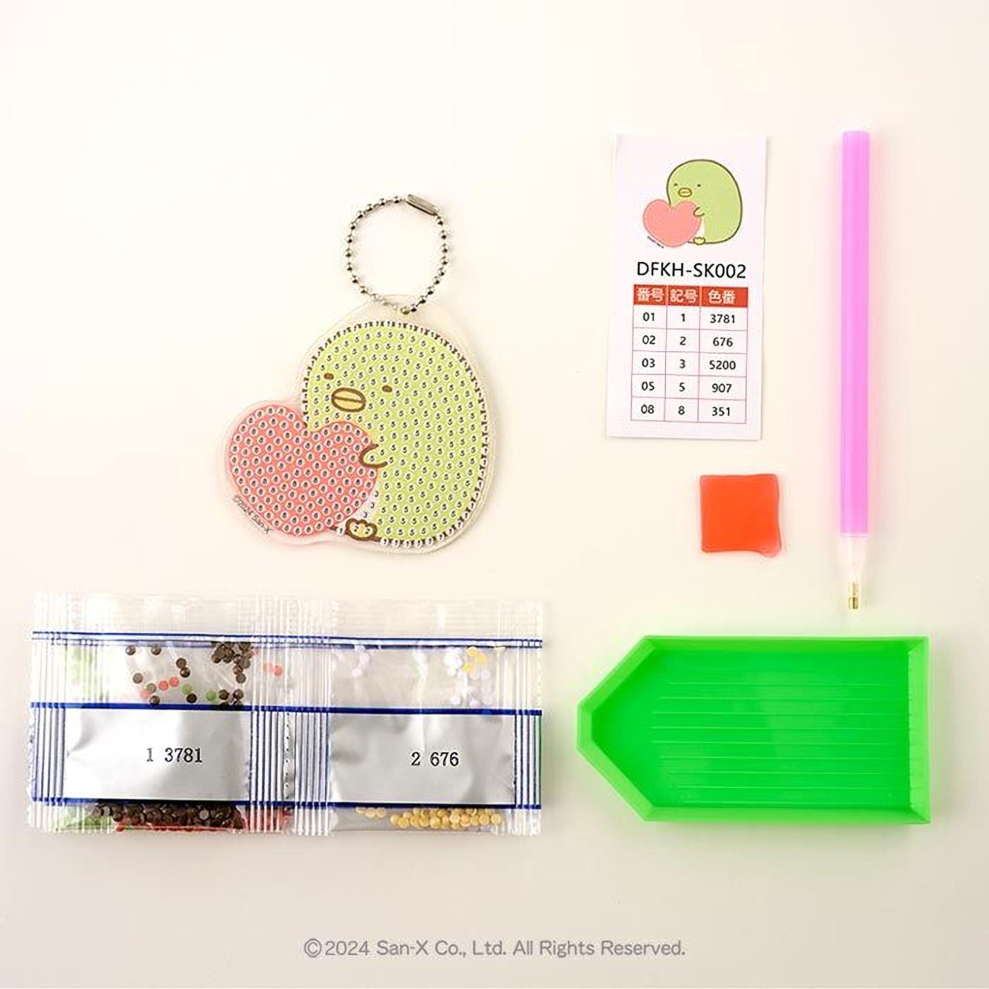 various items related to a craft or hobby, including a keychain, a price list, a pen, a green plastic tray, and a package of beads.