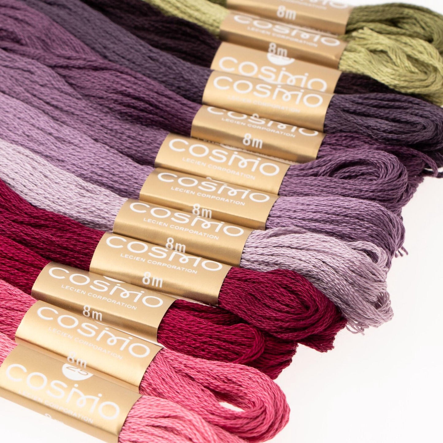 A collection of colorful spools of thread, each with a label indicating the type of thread it contains, such as 'Cosimo' and 'Lecen Organization'.