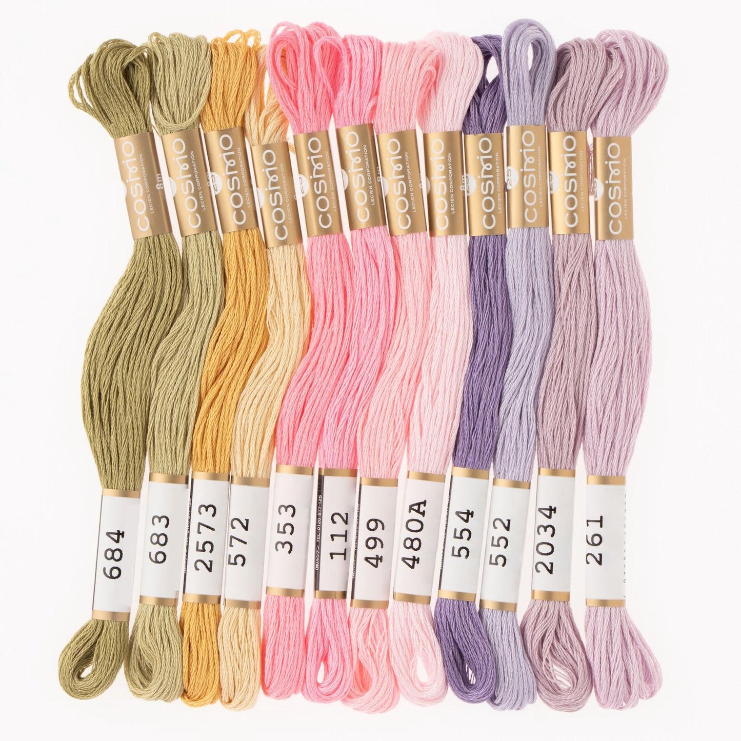 A collection of colorful spools of thread in various pastel shades, including green, yellow, pink, purple, and lavender.