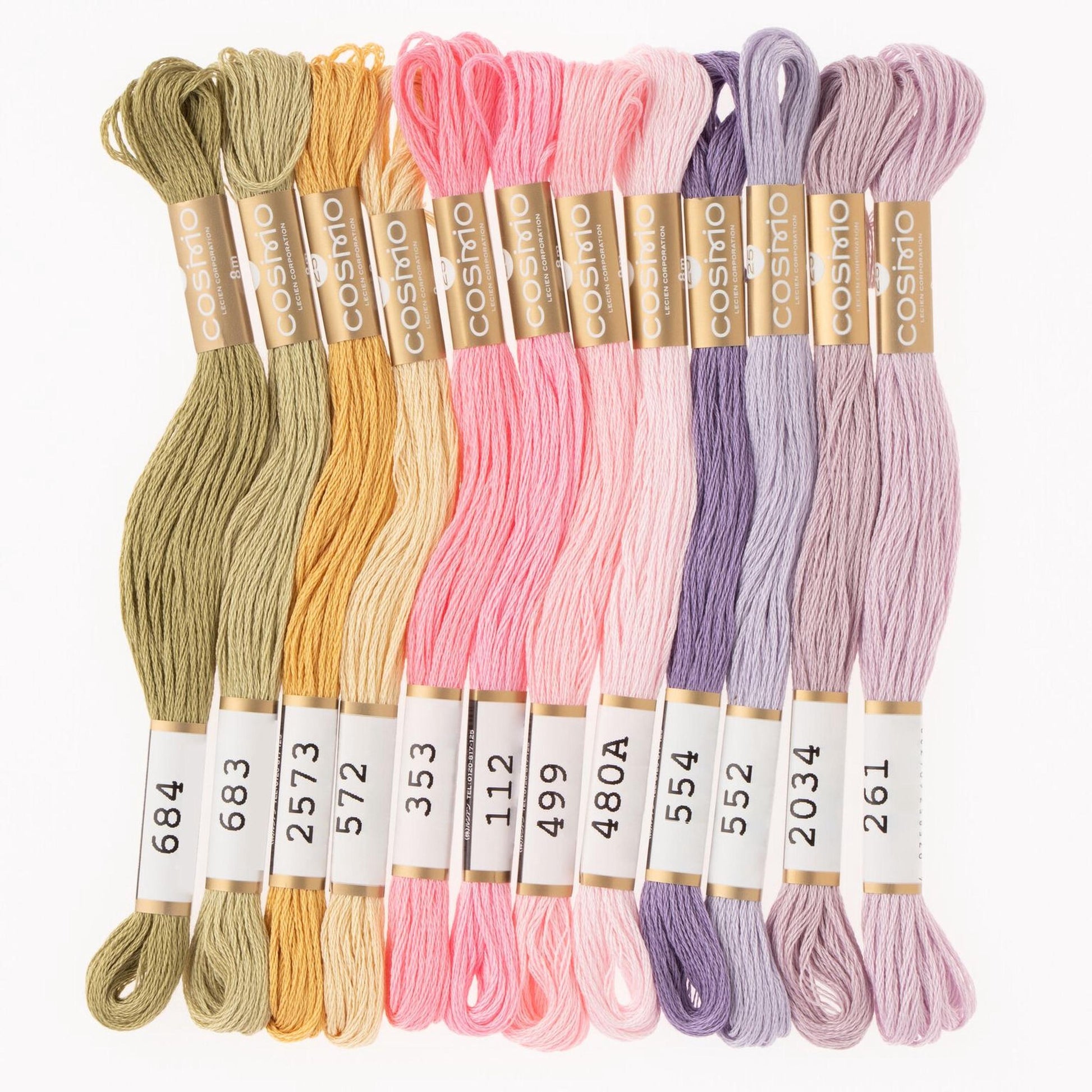 A collection of colorful spools of thread in various pastel shades, including green, yellow, pink, purple, and lavender.