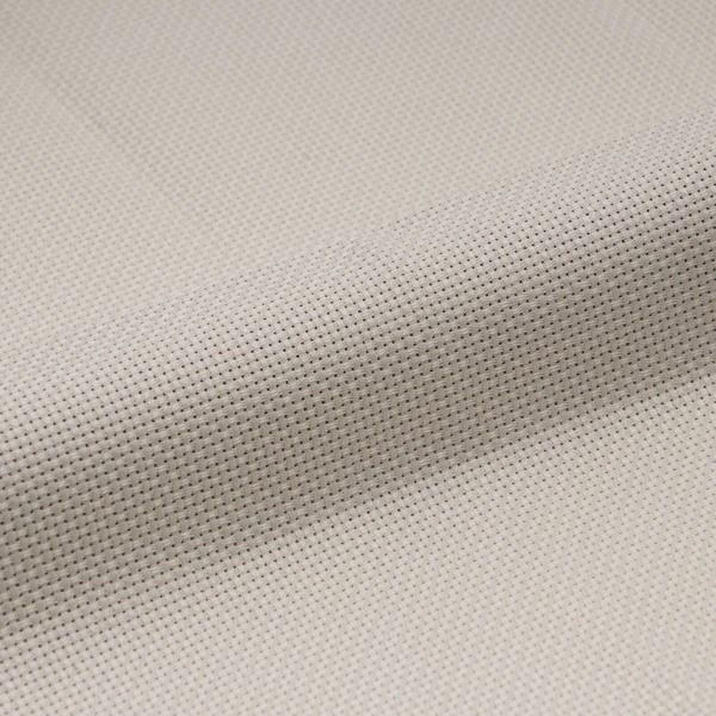 a close-up view of a fabric with a cross-stitch pattern, featuring a light beige color.