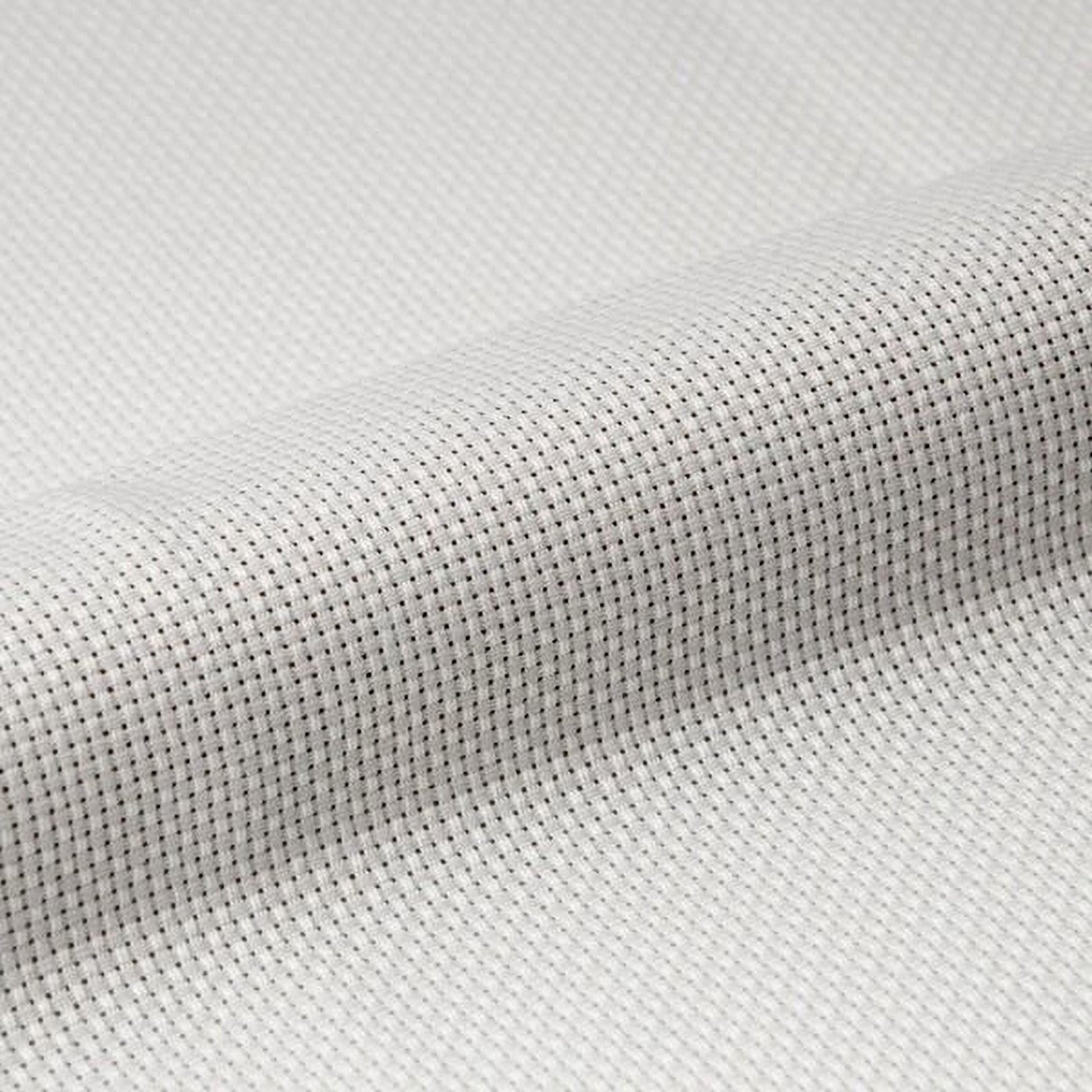 A close-up view of a white fabric with a textured, woven pattern.