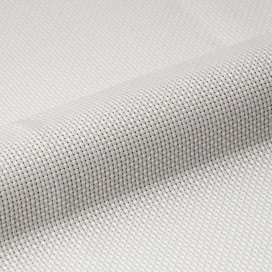 A close-up view of a white fabric with a textured, woven pattern.