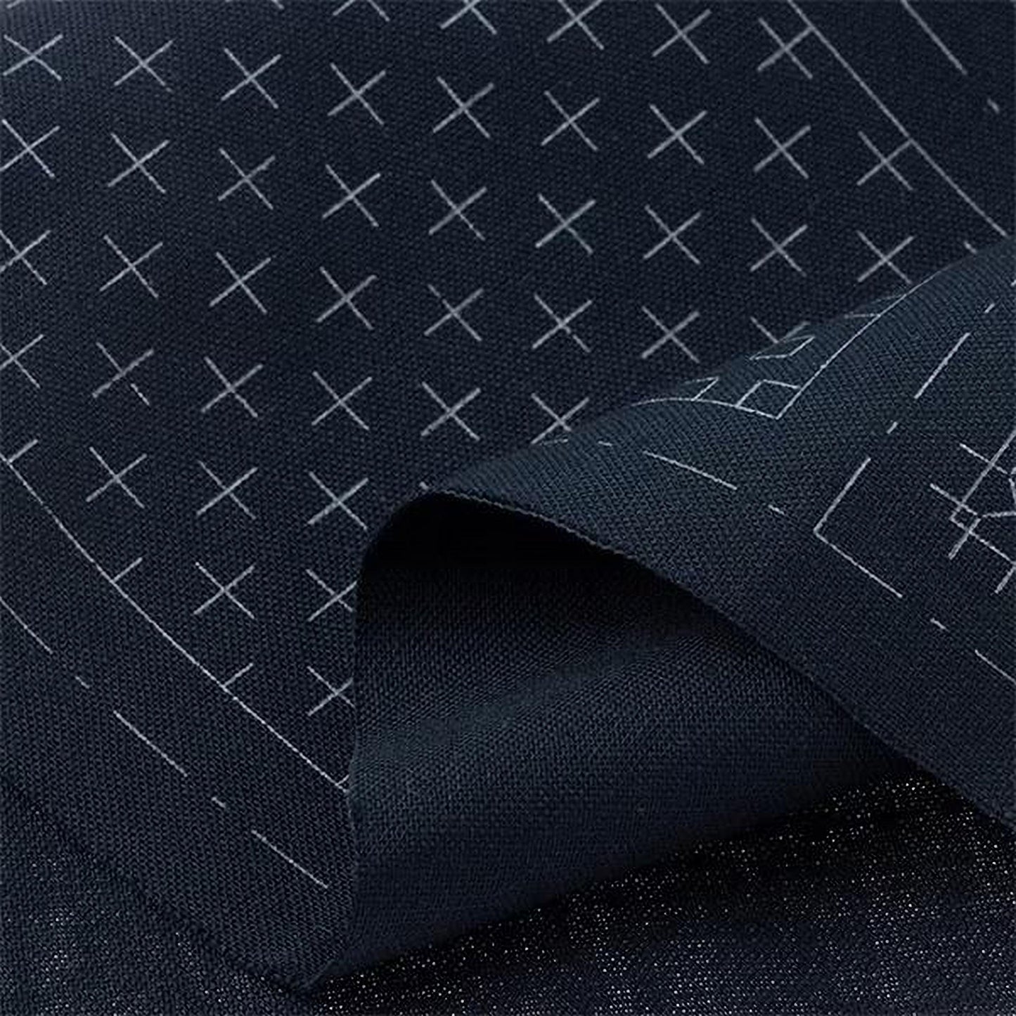 a close-up view of a dark fabric with a pattern of white crosses or lines on it.