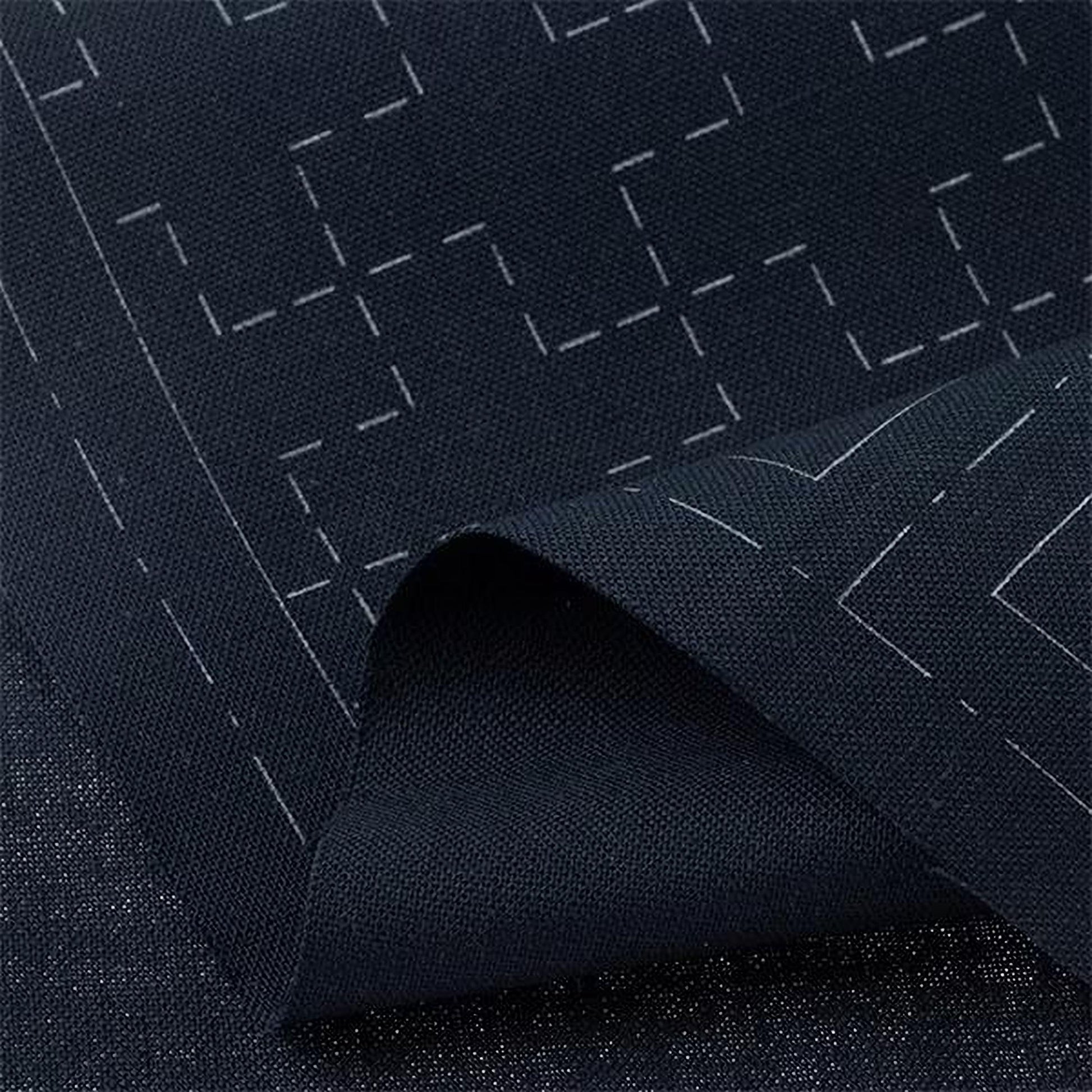 a close-up view of a dark fabric with a geometric pattern, featuring white lines and shapes.