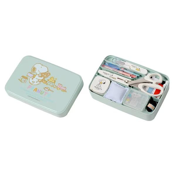 A light blue tin box containing various office and craft supplies, including scissors, pens, and other tools.