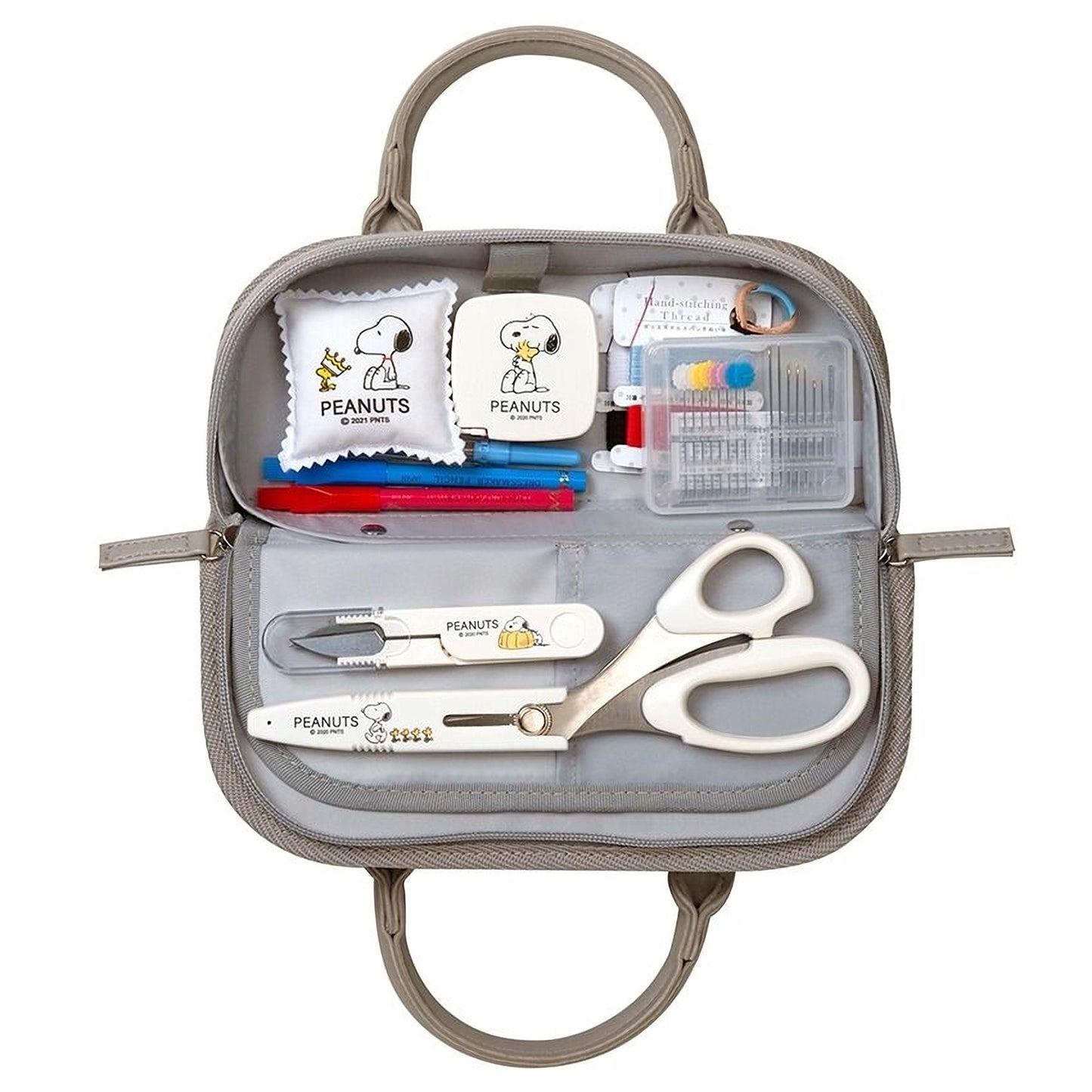A gray purse containing various Peanuts-themed items, including a Peanuts-themed sewing kit, Peanuts-themed scissors, and other Peanuts-themed accessories.