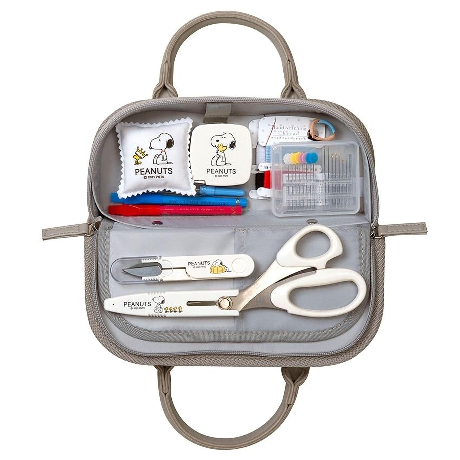 A gray purse containing various Peanuts-themed items, including a Peanuts-themed sewing kit, Peanuts-themed scissors, and other Peanuts-themed accessories.