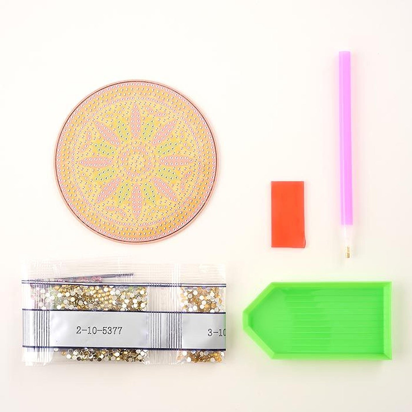 various craft supplies, including a pink pen, a green plastic tray, a clear plastic bag with glitter, and a red and orange object.