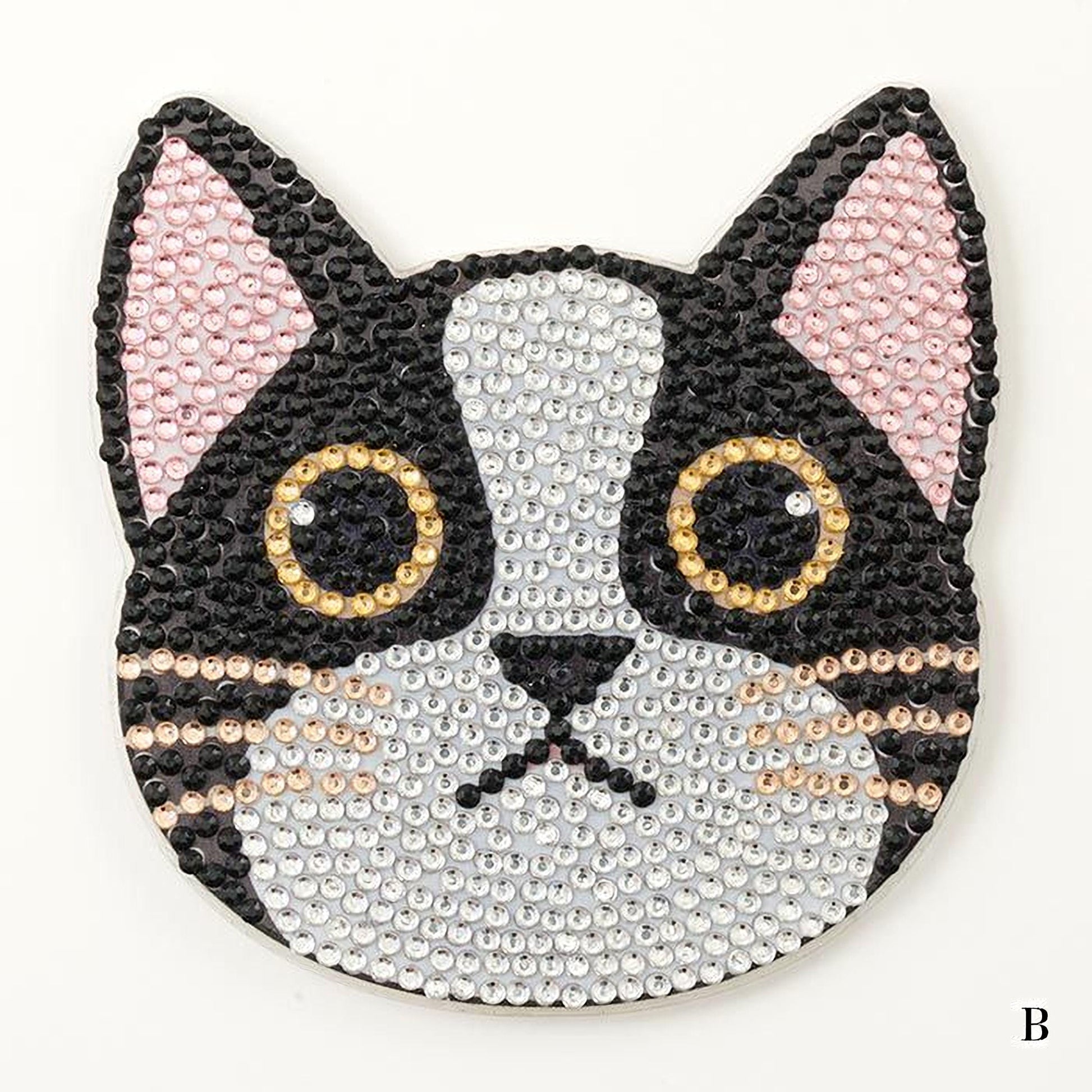 A close-up of a cat-shaped object made of small, colorful beads or sequins, with large, round eyes and a black and white pattern.