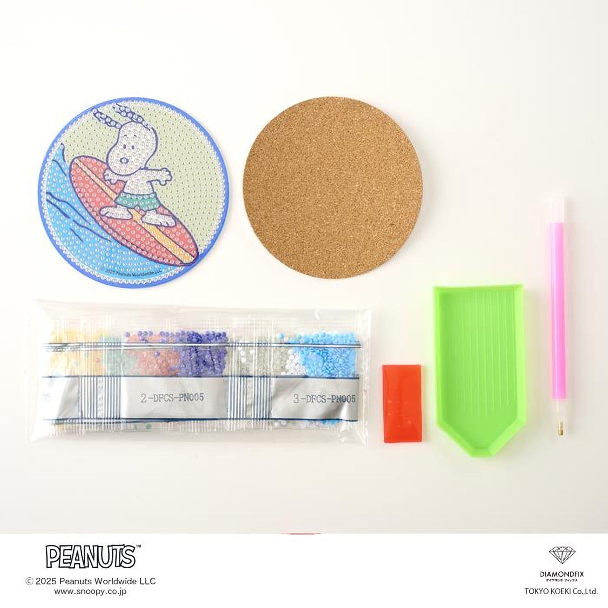 various Peanuts-themed items, including a surfboard sticker, a cork coaster, a pen, a plastic bag of beads, a diamond grater, and a pink pen.