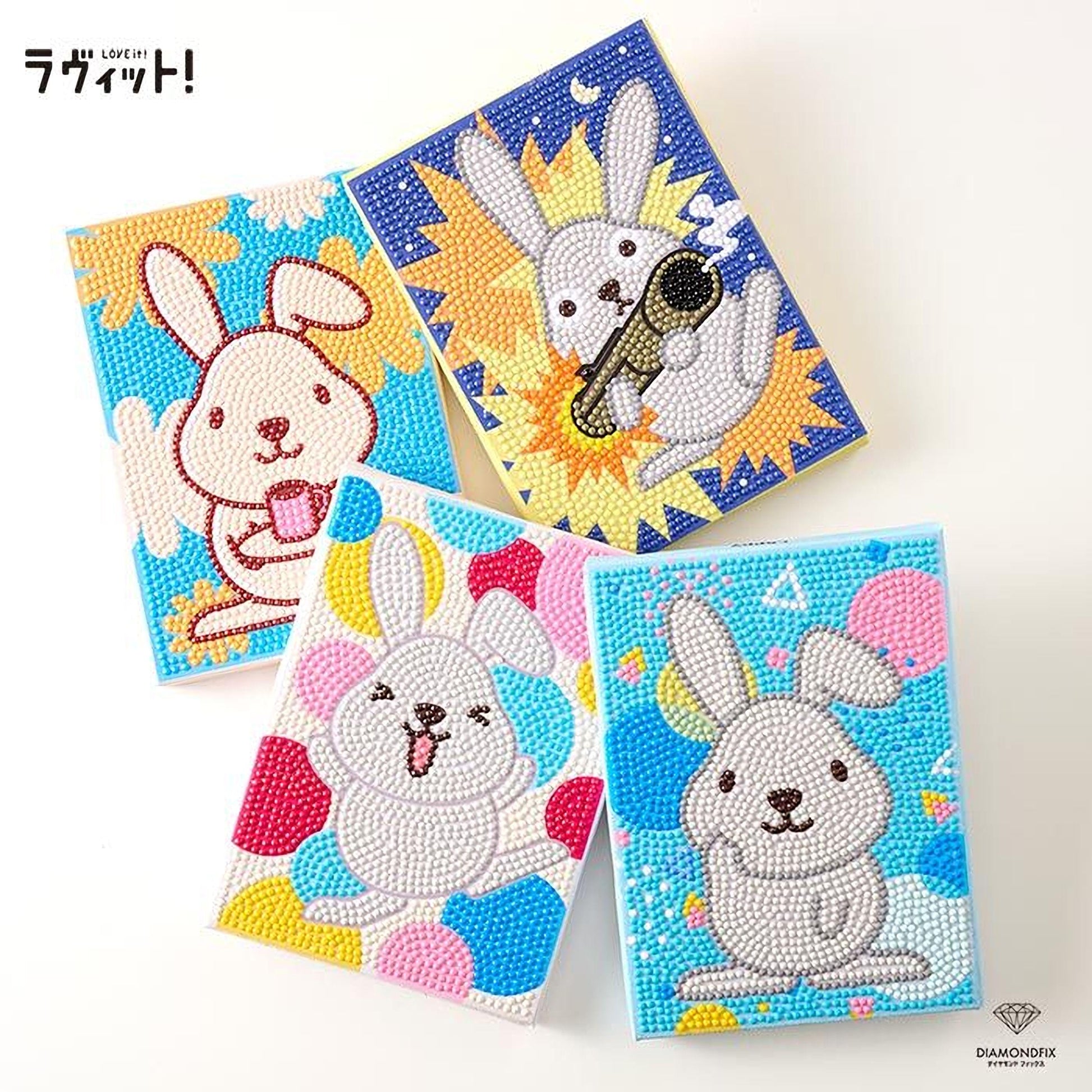 four colorful, hand-painted notebooks featuring cartoon rabbit designs.