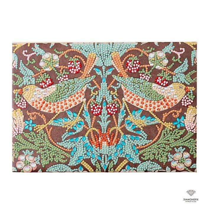 The image is a vibrant and intricate embroidered design featuring two birds, possibly cherubs, surrounded by a variety of colorful flowers and leaves. The design is composed of numerous small dots, creating a detailed and visually striking pattern.