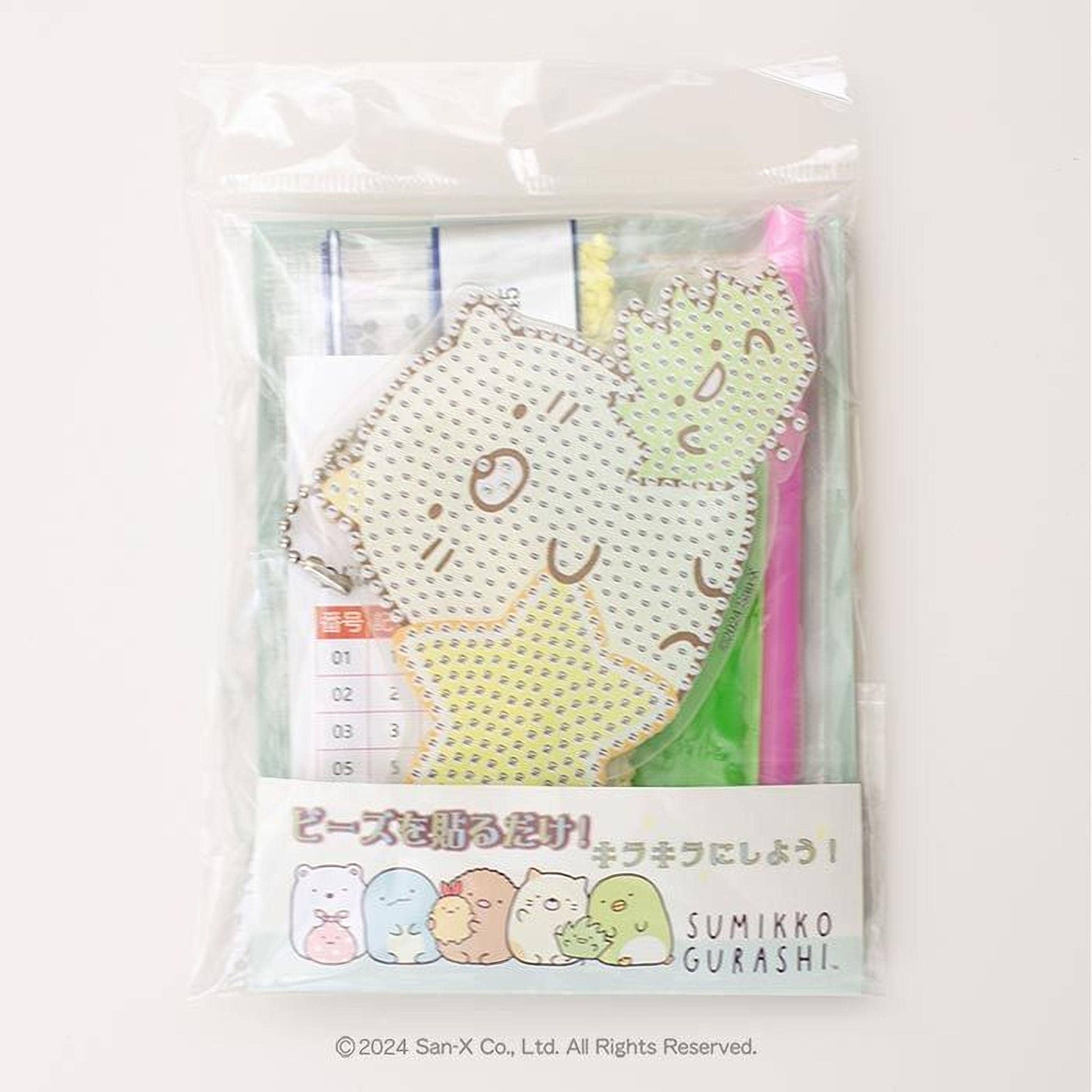 The image is a package containing a rhinestone-covered keychain with a cartoon character design.