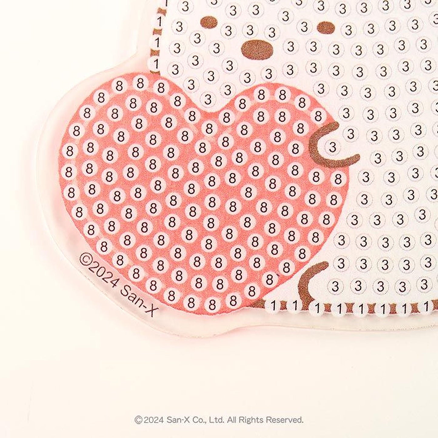 a close-up view of a heart-shaped object with a pattern of small circles on it, and the background is white.