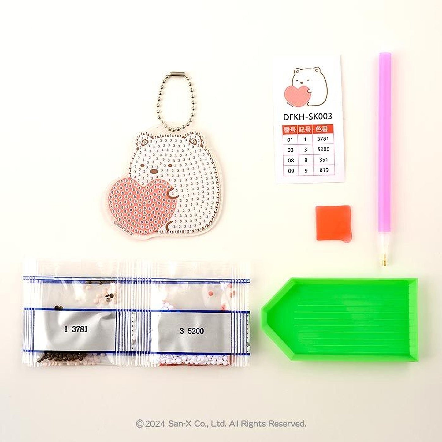 various items, including a keychain with a heart-shaped charm, a pink pen, a green diamond tool, and a price list.