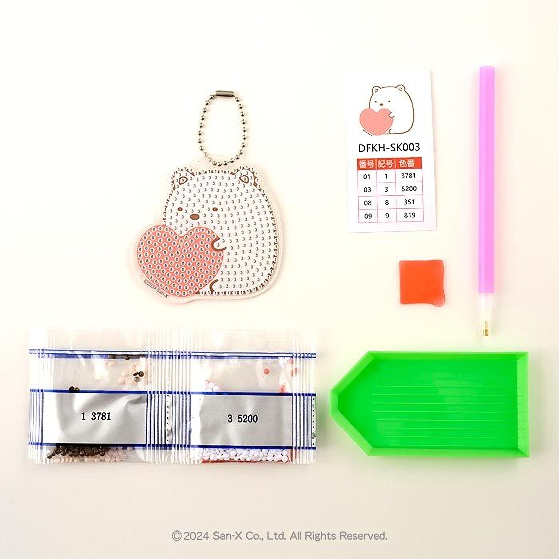 various items, including a keychain with a heart-shaped charm, a pink pen, a green diamond tool, and a price list.