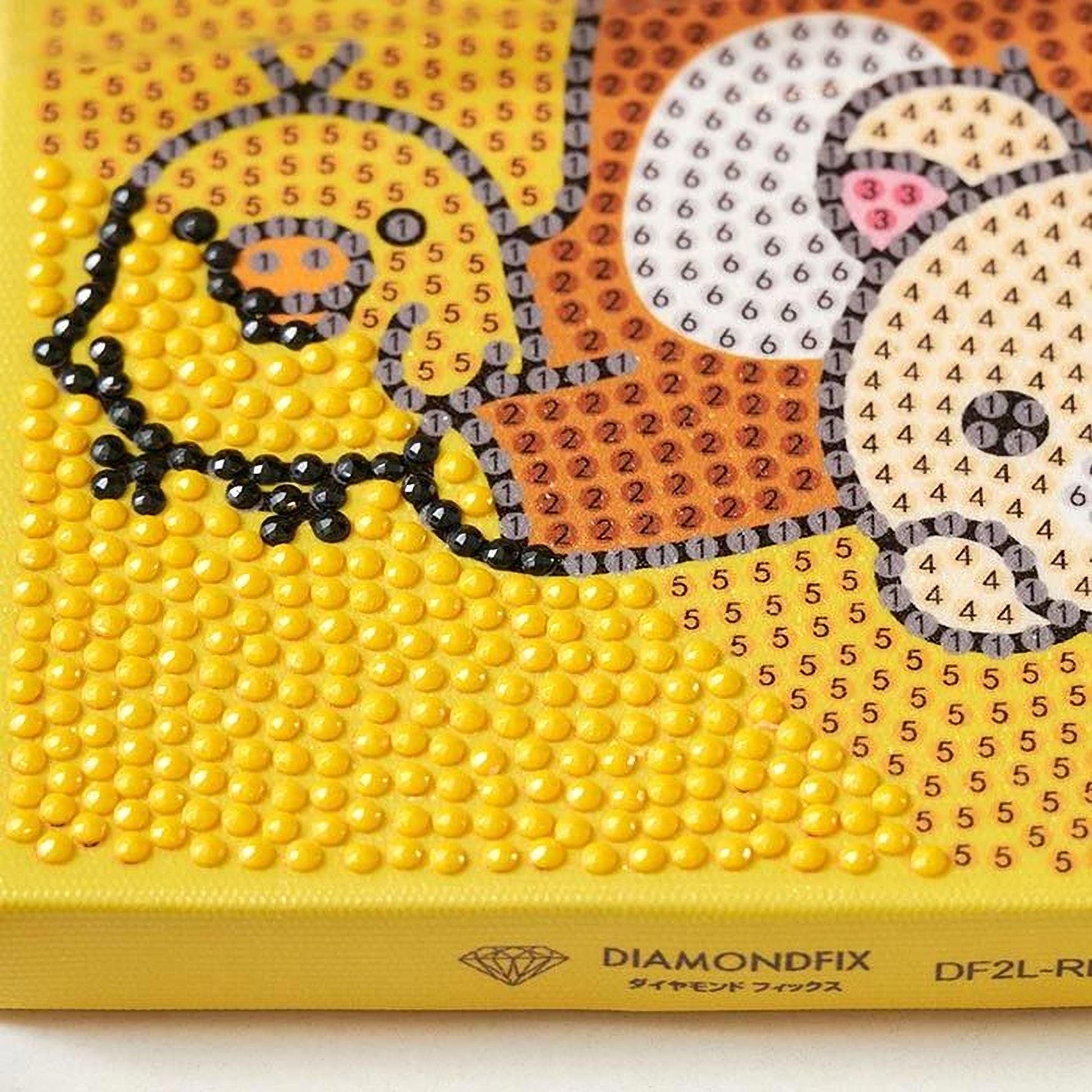 The image is a close-up of a yellow canvas with a pattern of small yellow dots, resembling a diamond-like design.