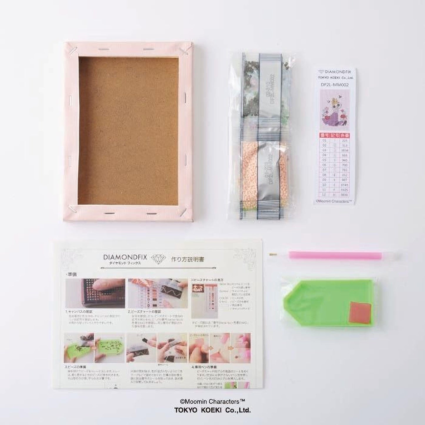 various items related to a DIY project, including a blank canvas frame, a set of diamond-shaped tools, a guidebook, and some other materials.