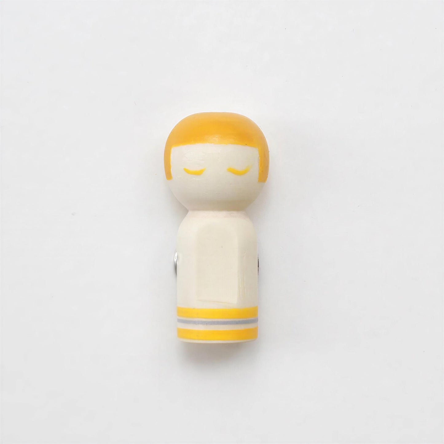 A small wooden figurine with a yellow head and arms, set against a plain white background.