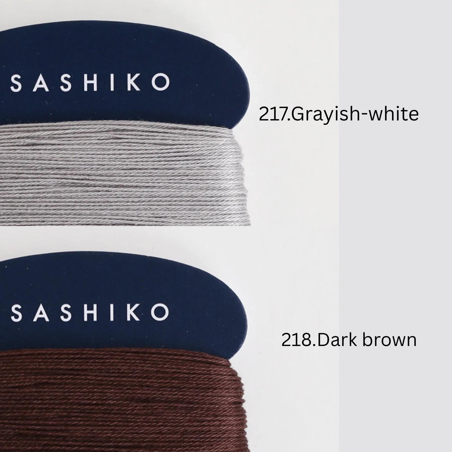two spools of thread, one in a dark blue color labeled "SASHIKO" and the other in a lighter gray color labeled "Grassy-white".