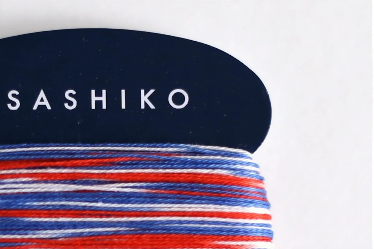 A close-up view of a spool of thread with the word "SASHIKO" printed on it in white text.