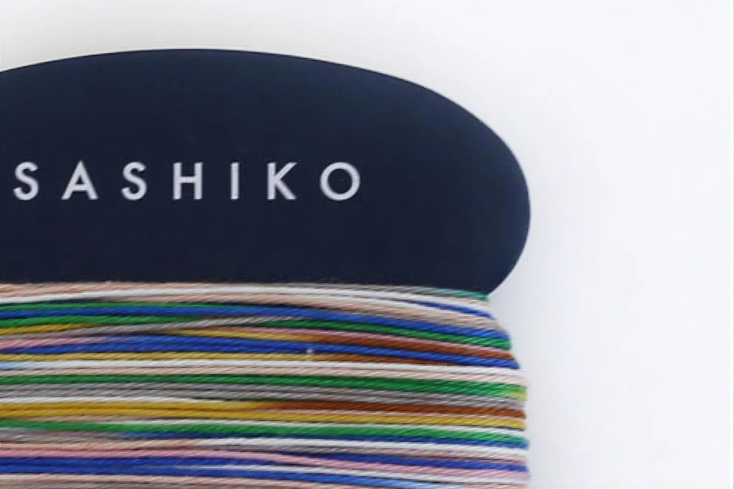 a close-up view of a dark blue object with the word "SASHIKO" written on it in white text.