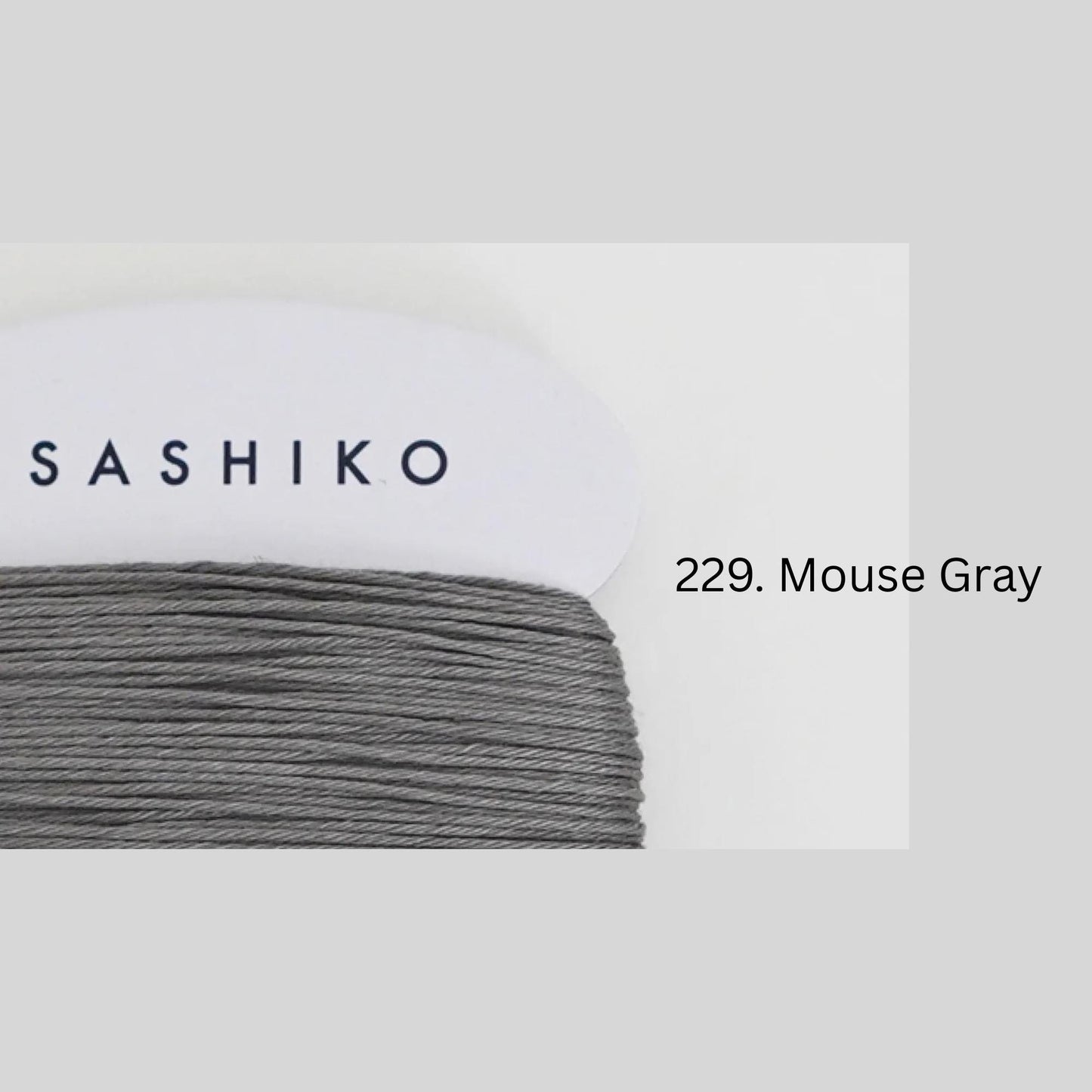 a close-up view of a spool of grey thread with the brand name "SASHIKO" printed on it.