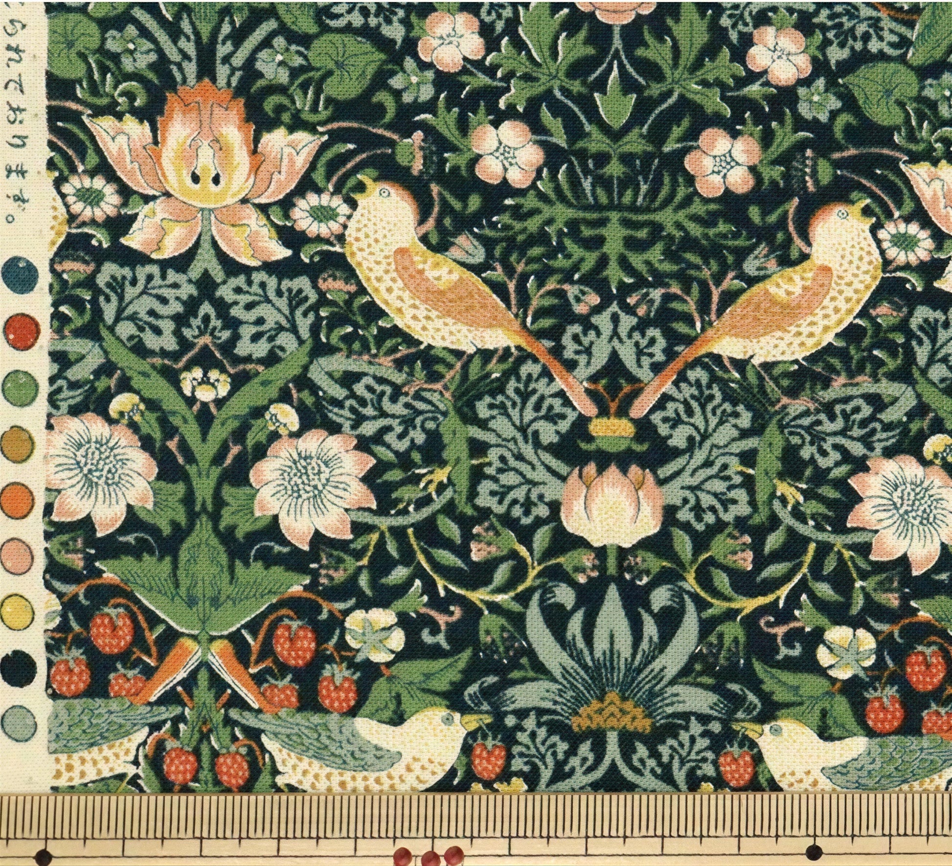 The image is a detailed and intricate textile pattern featuring a variety of birds, flowers, and berries in shades of green, pink, and orange. The pattern is rich in detail and complexity, showcasing the artist's skill and craftsmanship.