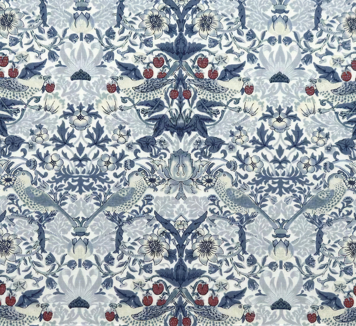 a repeating pattern of blue and white floral designs, including birds, flowers, and berries, creating a visually striking and intricate design.