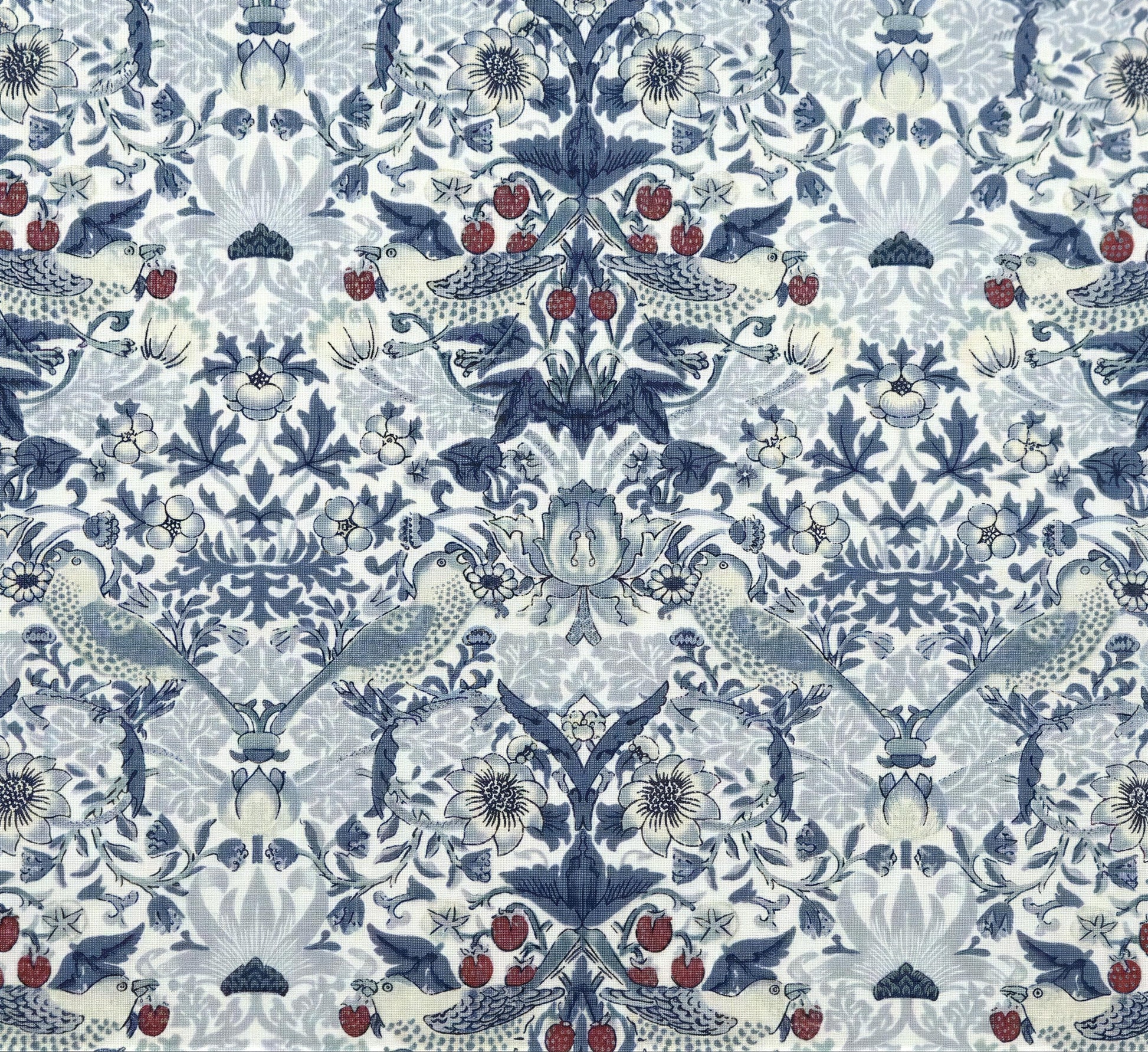 a repeating pattern of blue and white floral designs, including birds, flowers, and berries, creating a visually striking and intricate design.