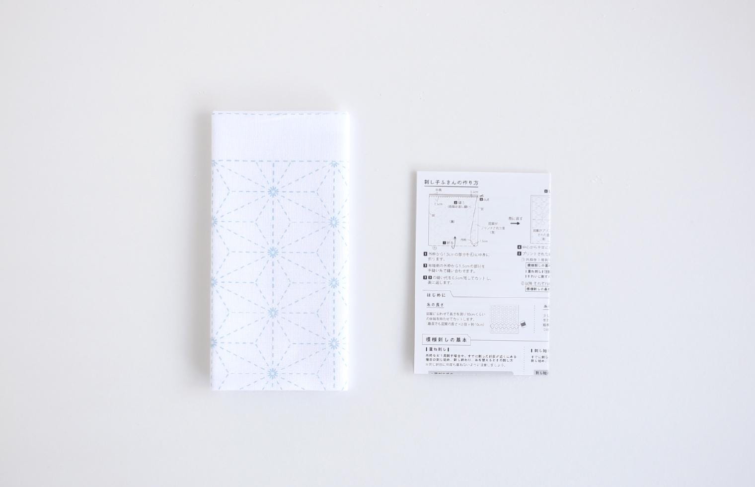 a white napkin with a blue geometric pattern and a white receipt with Japanese text.