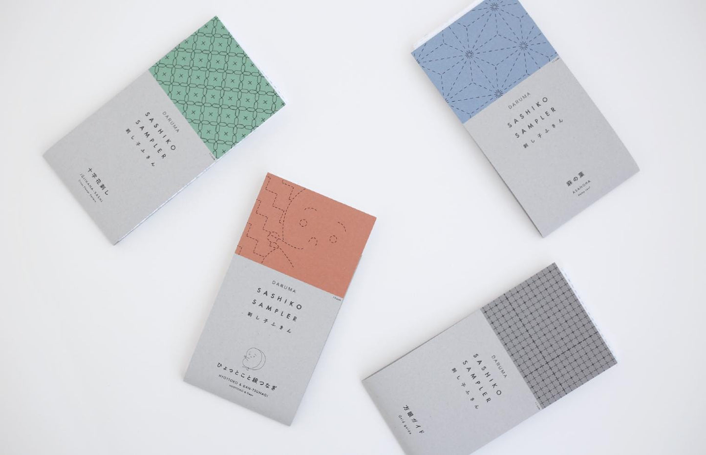 four different colored books or brochures with text and designs on their covers, arranged on a white background.