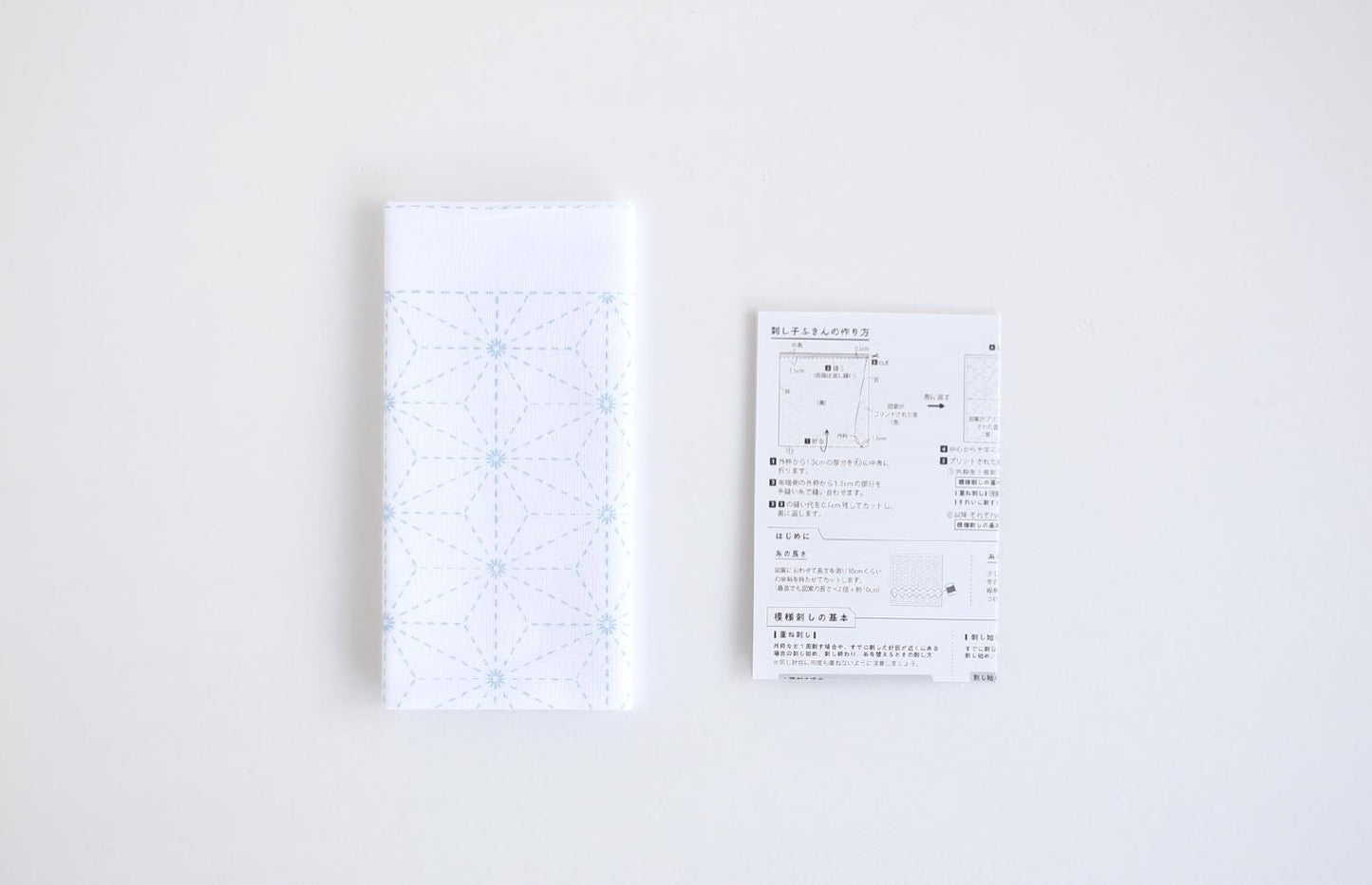 a white napkin with a blue geometric pattern and a white receipt with Japanese text.