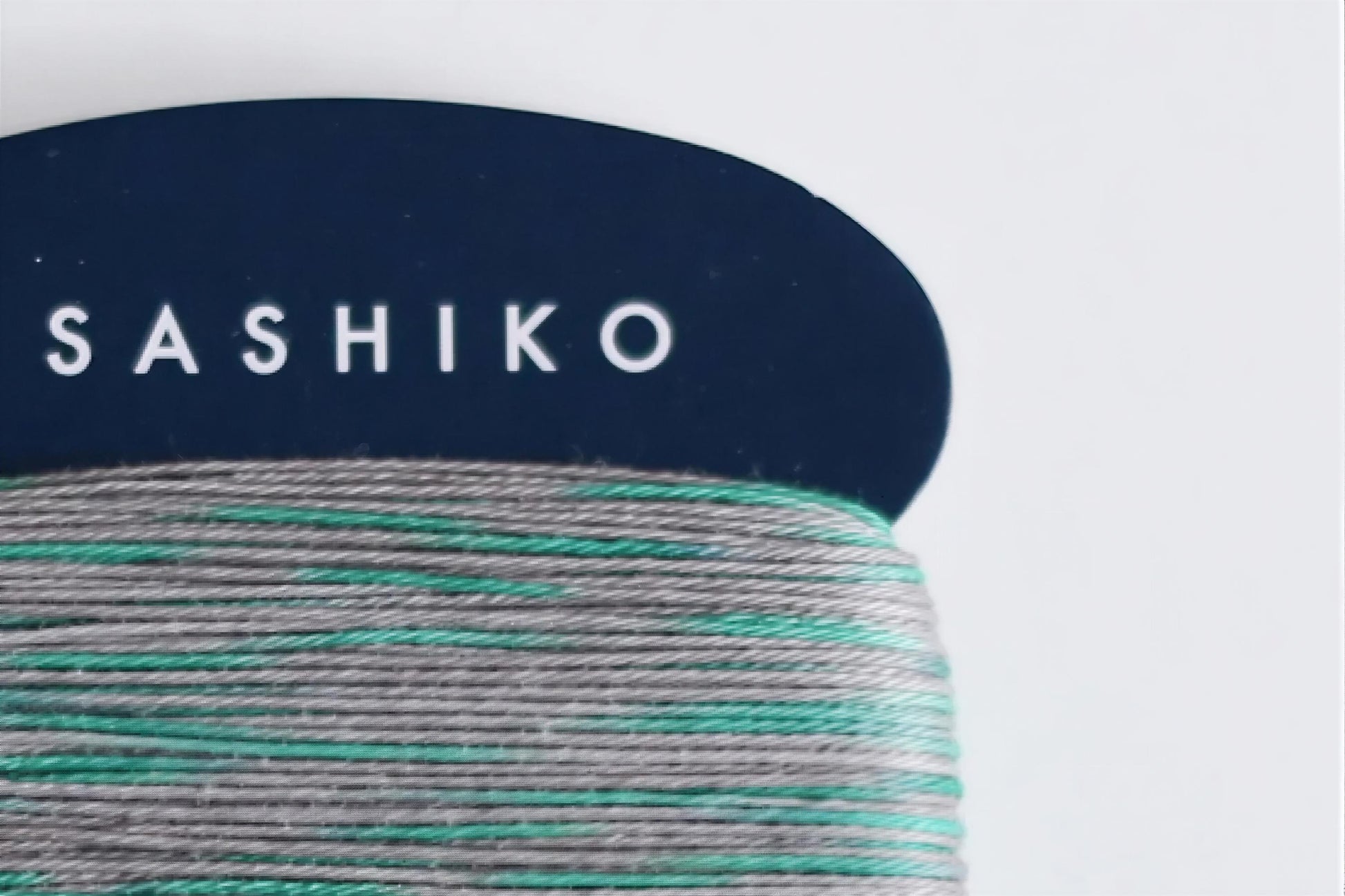 a close-up view of a blue object with the word "SASHIKO" written on it in white letters.