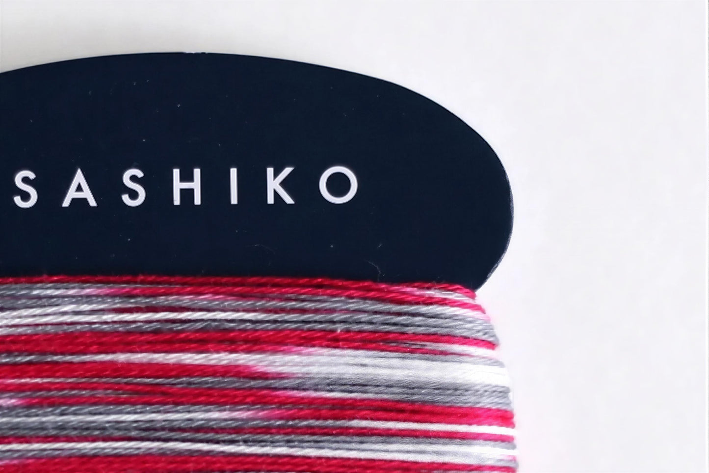 A close-up view of a black and white fabric with the word "SASHIKO" printed on it in white text.