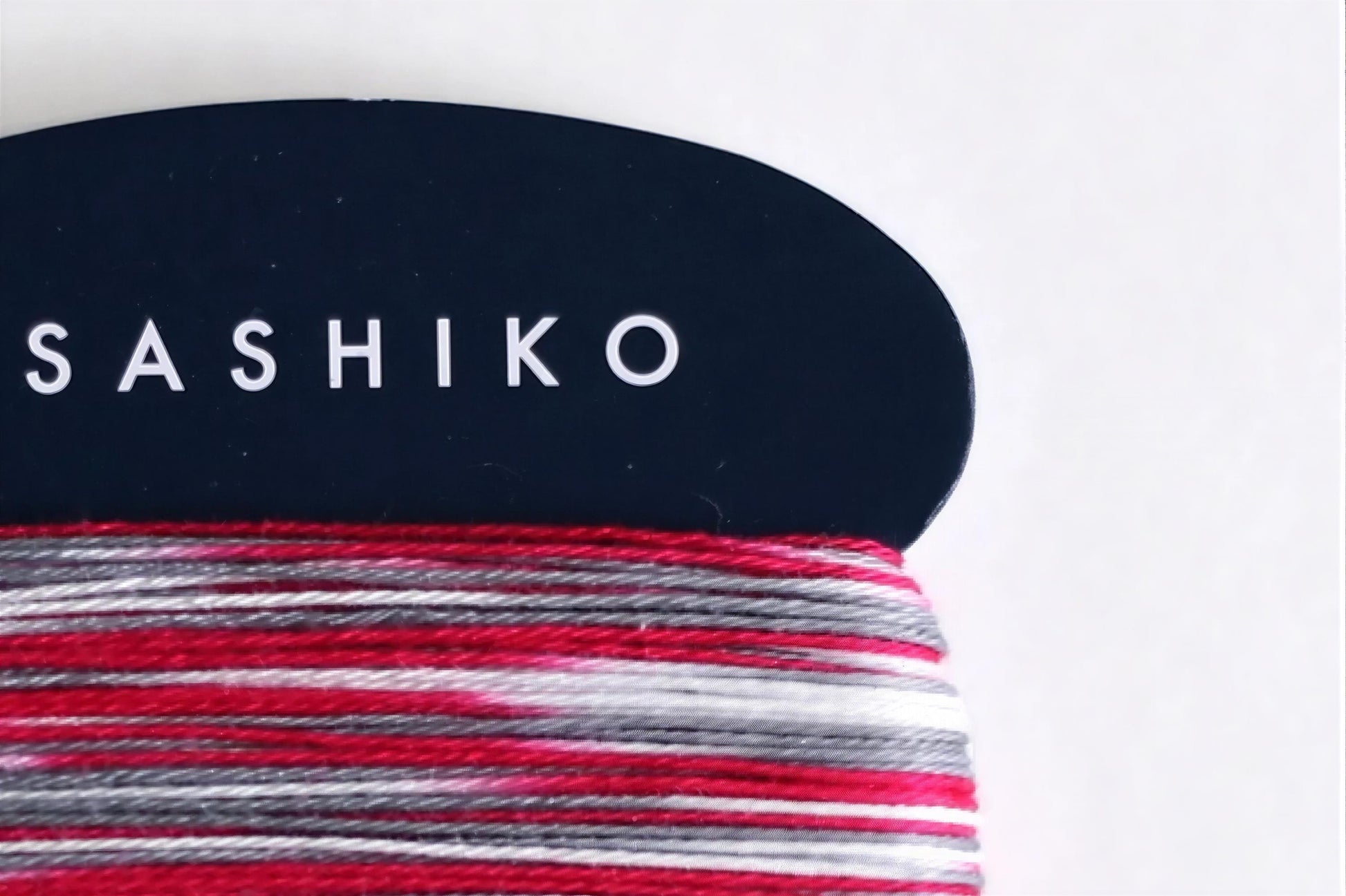 A close-up view of a black and white fabric with the word "SASHIKO" printed on it in white text.