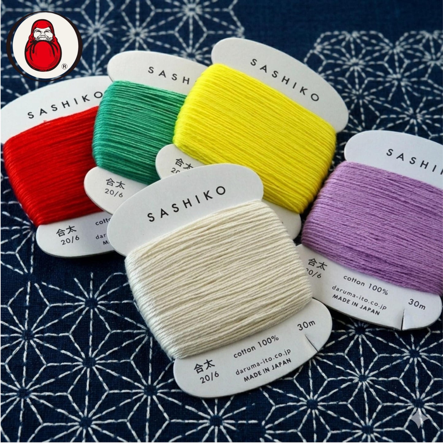 a collection of colorful spools of thread labeled "SASHIKO" on a patterned fabric background.