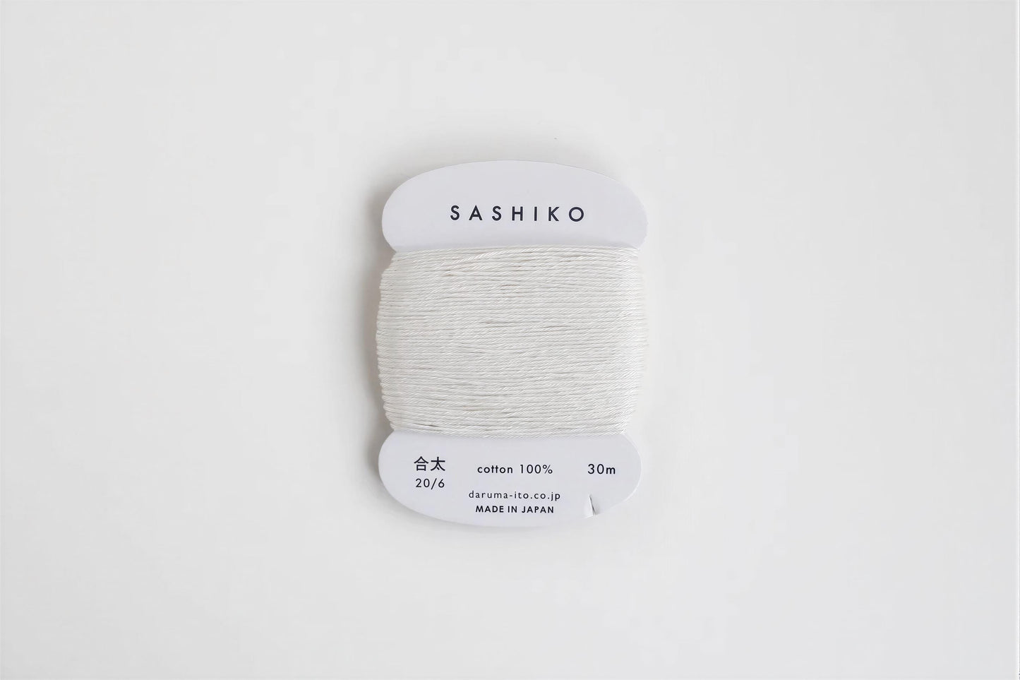 A spool of white thread labeled "SASHIKO" against a white background.